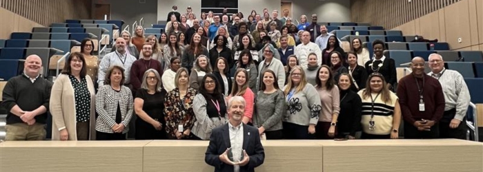 JCC Staff in the Wood Building Lecture Hall with Dr. Lindquist holding the Innovations award